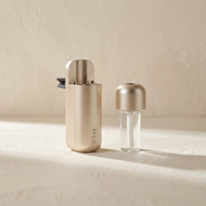 Drip of Infinity Air Vent Diffuser geöffnet mit Nachfüllflakon auf hellem strukturiertem Hintergrund