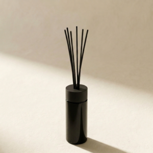 Reed Diffuser Devil Fruit in dunkelviolettem Glas vor warm neutralem Hintergrund