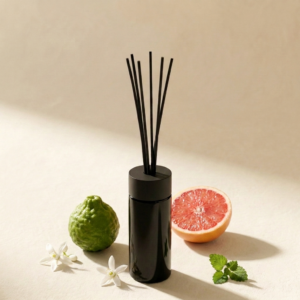 Reed Diffuser Senzafino in dunkelviolettem Glas vor weichem vanillebeigem Hintergrund